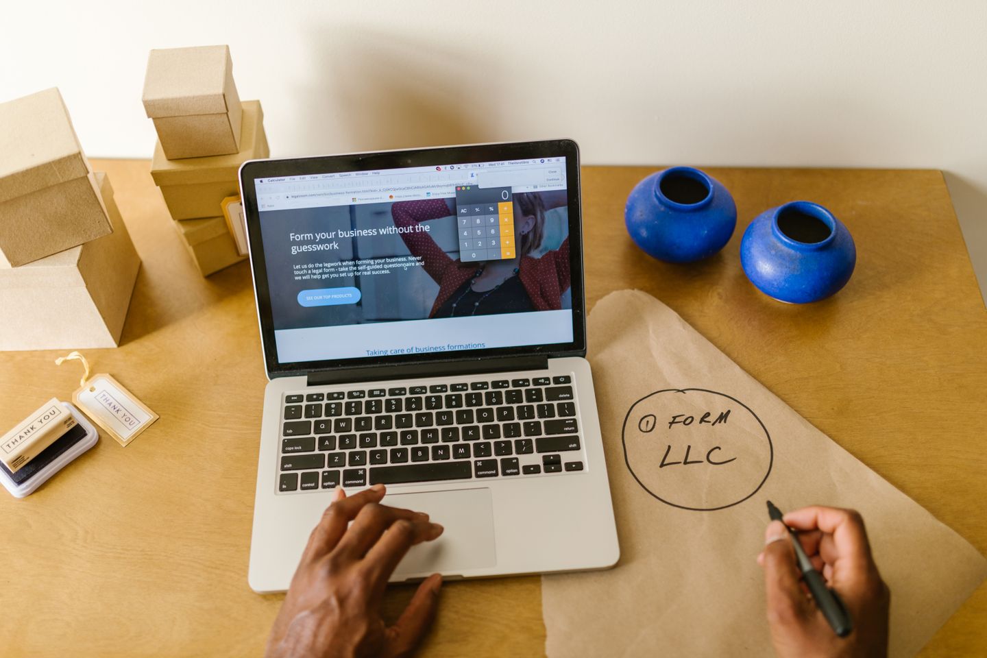 A workspace with a laptop, packaging and business planning notes.