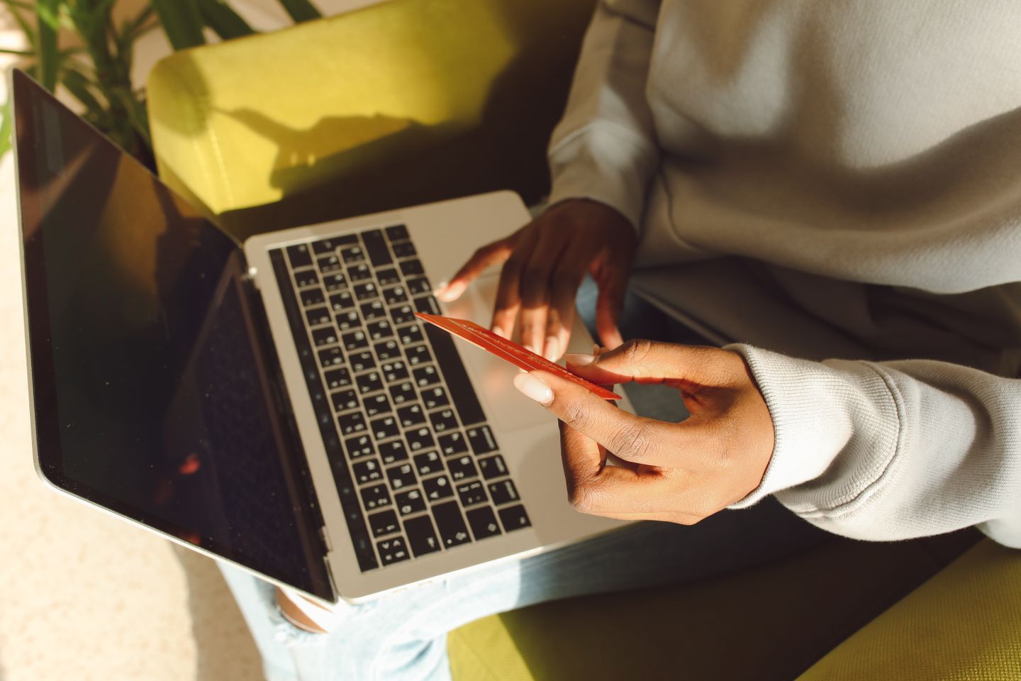A customer using a laptop and holding a payment card.